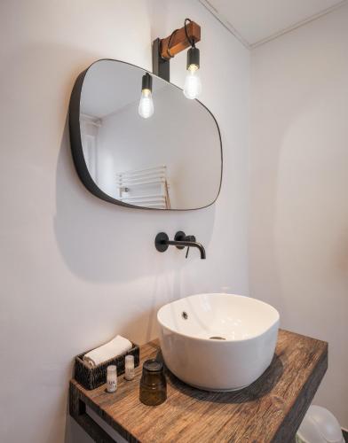 a bathroom with a white sink and a mirror at Amanthos Living Nyon in Duillier