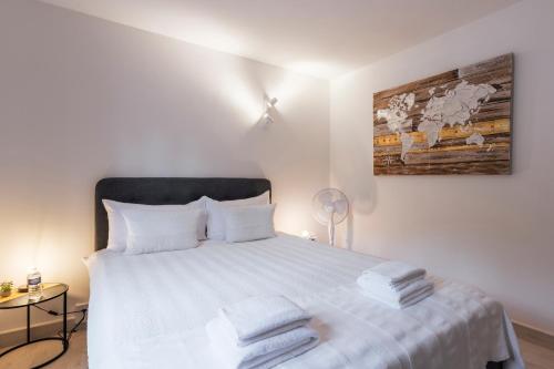 a bedroom with a white bed with towels on it at Amanthos Living Nyon in Duillier