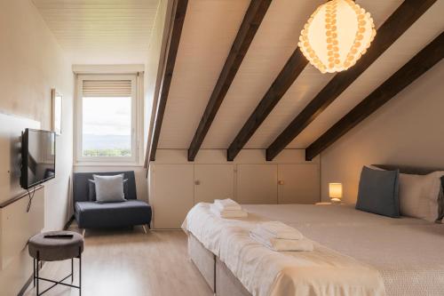 a bedroom with a large bed and a chair at Amanthos Living Nyon in Duillier