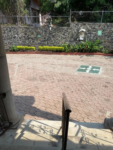 a brick walkway with a green and white cross on it at Quinta Ángeles in Cuernavaca