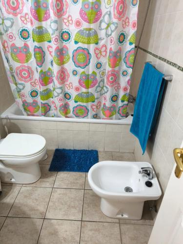 a bathroom with a toilet and a sink and a shower curtain at Jardín Marino in Puerto de Santiago