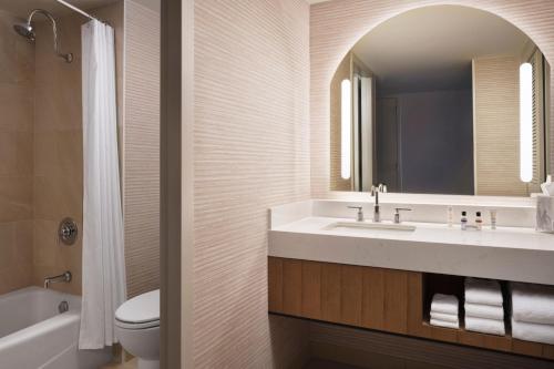 a bathroom with a sink and a toilet and a mirror at Marriott Marquis San Diego Marina in San Diego