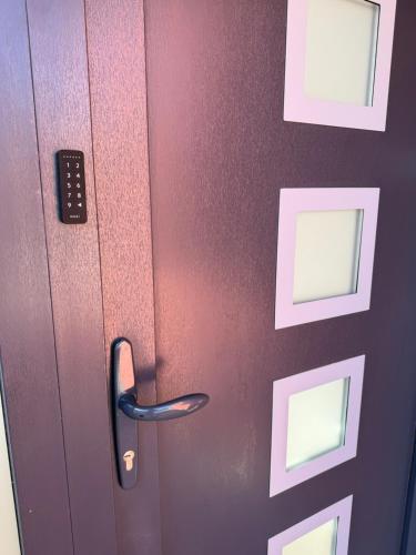 a door with a black handle and pictures on it at Hestia Suite in Zaječar