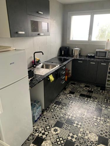 une petite cuisine avec un évier et un réfrigérateur dans l'établissement Cosy home, à Aulnay-sous-Bois