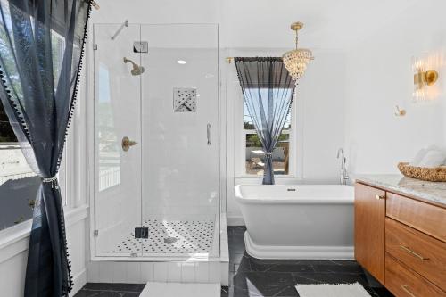 a bathroom with a shower and a white tub at Charming Salt Lake City Home Minutes from Airport, Downtown SLC , Skiing in South Salt Lake