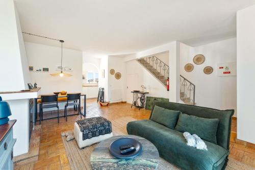 a living room with a green couch and a table at Casa Matea in Figueira