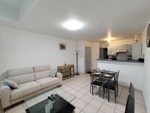 un salon avec un canapé et une table dans l'établissement Appartement climatisé avec vue sur la cité, à Carcassonne