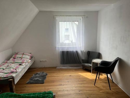 a bedroom with a bed and a table and a window at Charmante, helle Wohnung mit Garten nahe Legoland in Nersingen