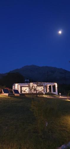 a house in a field at night with the moon at Boutique apartments Myesis in Samothráki