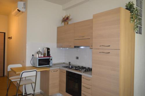a kitchen with wooden cabinets and a stove and a microwave at La Casetta tra Chianti e Firenze in Scandicci
