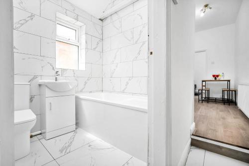 a white bathroom with a tub and a toilet at 1 Bed Apartment Birmingham Resorts World NEC BHX in Birmingham