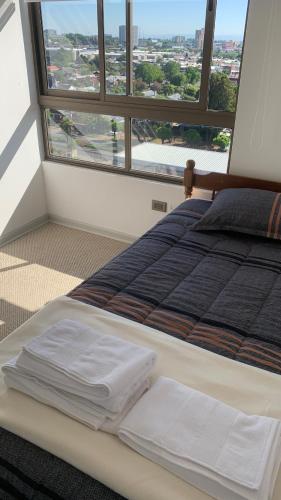 a bed in a room with a large window at Hermoso Departamento en Los Angeles in Los Ángeles