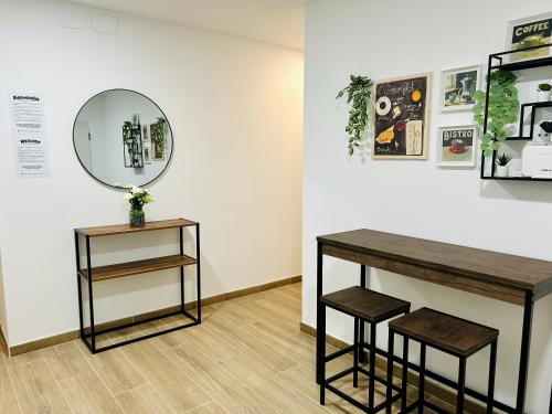 a room with a table and two stools and a mirror at Rooms Chima in Madrid