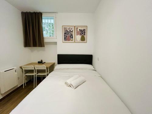 a small room with a bed and a small table at Rooms Chima in Madrid