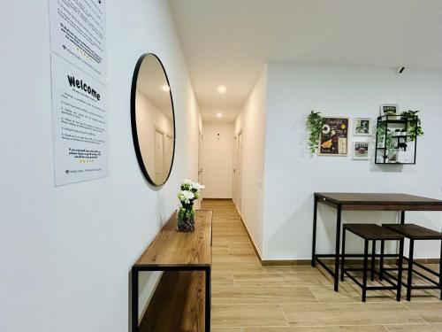 a hallway with a table and a mirror on a wall at Rooms Chima in Madrid