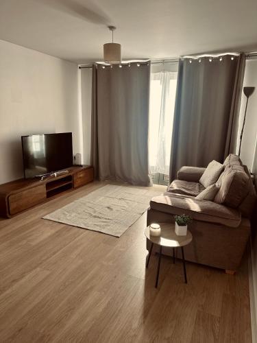 a living room with a couch and a flat screen tv at Wolverhampton Apartment with Free Parking 1 minute from the train station in Wolverhampton