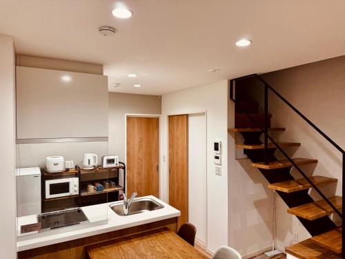 cocina con fregadero y escalera en Niseko Purr 103, en Kutchan