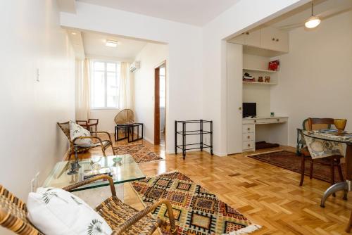 ein Wohnzimmer mit Tisch und Stühlen in der Unterkunft Vista lateral mar, rua tranquila e arborizada in Rio de Janeiro