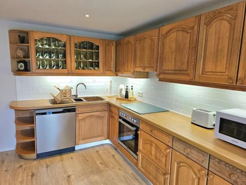 a kitchen with wooden cabinets and a counter top at Giertensmühle Mesenich in Langsur
