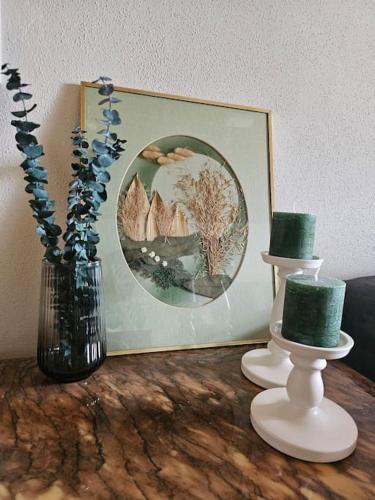 a table with two vases and a painting and a picture at Giertensmühle Mesenich in Langsur