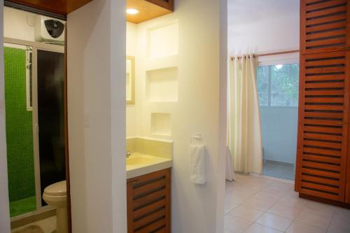 a bathroom with a sink and a toilet and a shower at Yaxche Condo in Playa del Carmen