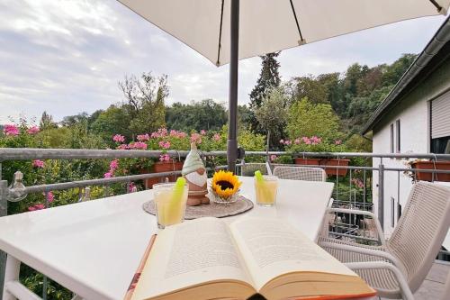 a white table with an open book and glasses of orange juice at Giertensmühle Mesenich in Langsur