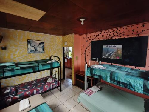 a room with two bunk beds and a tv at Hostal Doña Mercedes in Juayúa