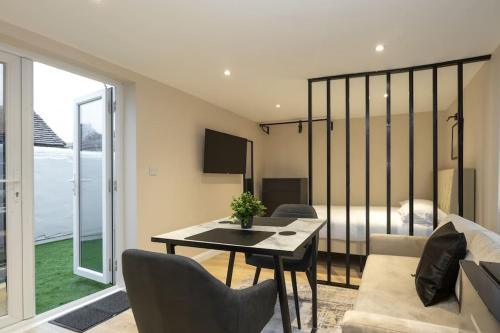 a living room with a table and a bedroom at Modern Studio Apart Large Garden in Stoke on Trent