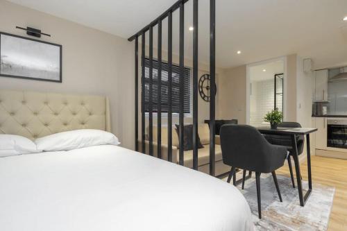 a bedroom with a bed and a desk and a kitchen at Modern Studio Apart Large Garden in Stoke on Trent