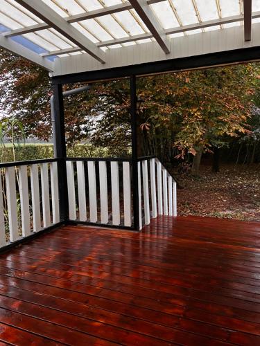 a porch with a white roof and a wooden deck at Hygge Green Retreat Billund in Grønbjerg