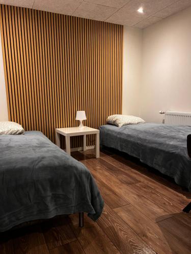 a room with two beds and a striped wall at Hygge Green Retreat Billund in Grønbjerg