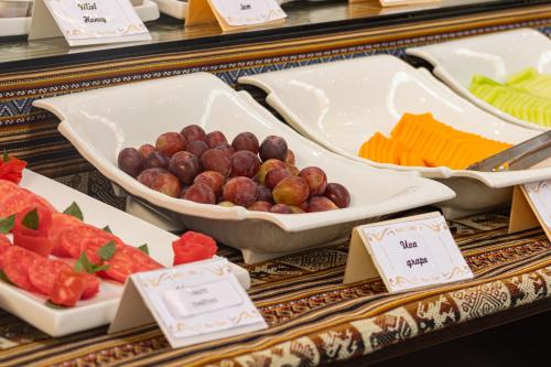 a buffet of food with fruits and vegetables in trays at Hotel Kapac Inn-San Blas in Cusco