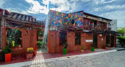 a brick building with a mural on the side of it at La Liliana Hostal - Gastrobar in Jagua