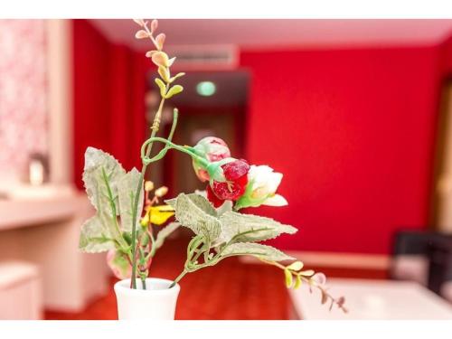 a white vase filled with flowers in a room at Lara Hotel and Spa in Baku