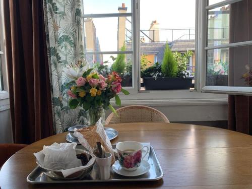 - une table avec un plateau avec un vase de fleurs dans l'établissement Charmant studio confortable dans la plus belle capitale, à Paris