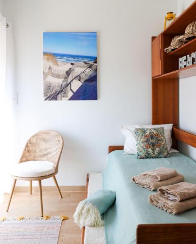 a bedroom with a bed with a chair and a table at Beachfront apartment T2 Costa Nova Surf Aveiro in Gafanha da Encarnação