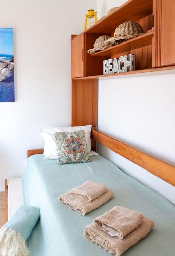 a bedroom with a bed with two towels on it at Beachfront apartment T2 Costa Nova Surf Aveiro in Gafanha da Encarnação