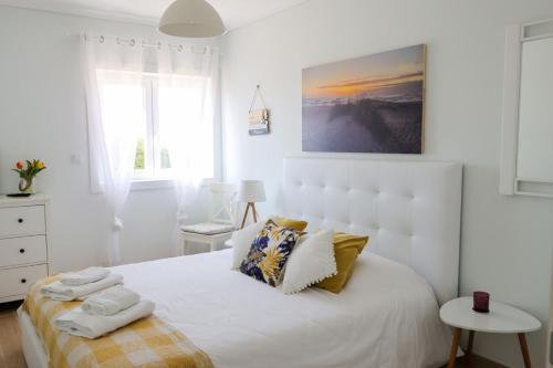 a bedroom with a white bed with towels on it at Beachfront apartment T2 Costa Nova Surf Aveiro in Gafanha da Encarnação