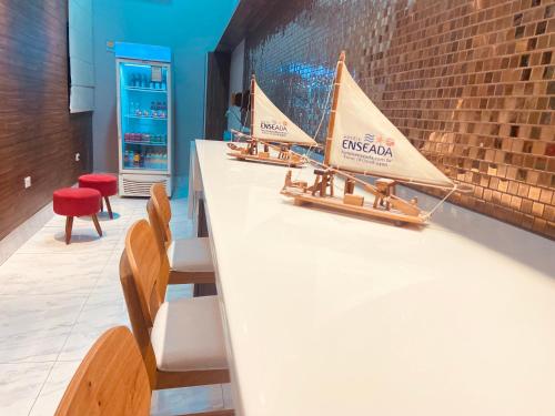 two model boats sitting on a counter with chairs at Hotel Enseada Boa Viagem in Recife