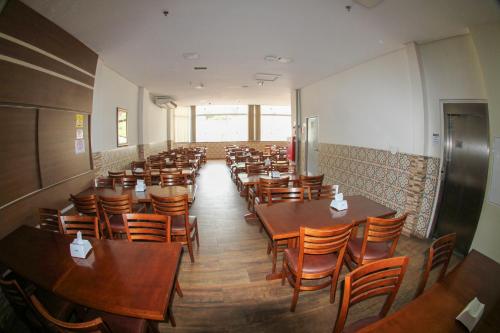 a room with tables and chairs in a restaurant at Hotel Maria da Fé in Aparecida