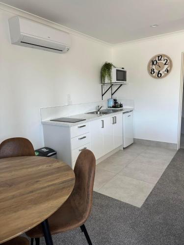 a kitchen with a wooden table and a sink at Centre Court Motel in Blenheim