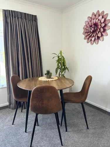 a dining room table with chairs and a plant on it at Centre Court Motel in Blenheim