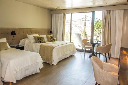 Habitación de hotel con 2 camas y balcón en Nuit Hotel en Mar del Plata