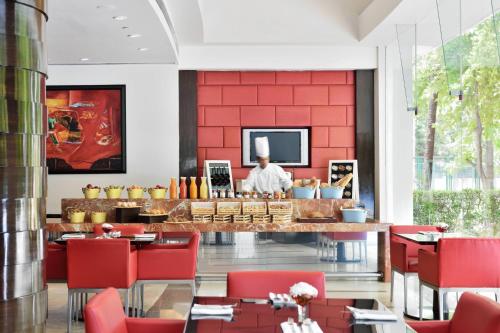 a restaurant with red walls and a chef in the background at Marriott Executive Apartment - Lakeside Chalet, Mumbai in Mumbai