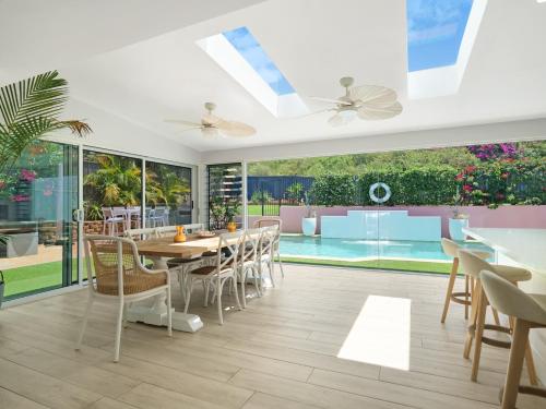 a dining room with a table and chairs and a pool at Swell in Anna Bay
