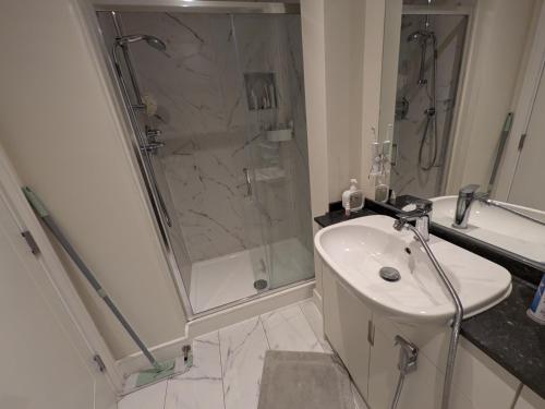 a white bathroom with a shower and a sink at Pvt room with direct train to city center 25 mins in Dublin