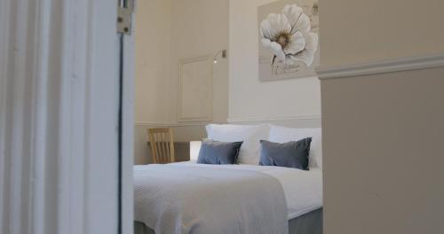 a bedroom with a white bed with blue pillows at Entire 8 Ensuite Bedroom Coastal Holiday Home Townhouse, Free Parking, Fully Equipped Kitchen, Dining Room & Lounge, Perfect for Family Gatherings, Long Term Contractor, Relocation, etc Stays, 20 mins to Sunderland & Newcastle, See our Site for Assurance in South Shields