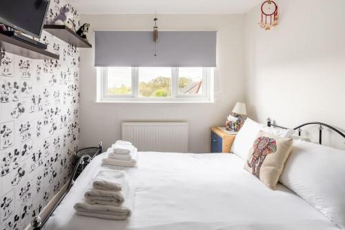 a bedroom with a white bed with towels on it at Spacious 3bed semi/Gamesroom/Drive/10mins to City in Wrexham