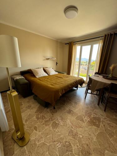 une chambre avec un lit, une table et une fenêtre dans l'établissement T2 coloré proche mer terrasse parking, à Six-Fours-les-Plages