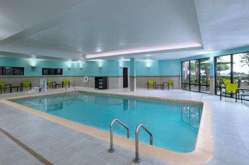 a pool in a hotel with chairs and tables at SpringHill Suites by Marriott Dallas DFW Airport East Las Colinas Irving in Irving
